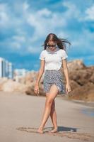 Adorable teen girl has fun at tropical beach during vacation photo