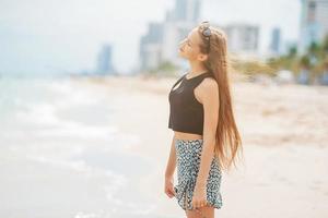 niña feliz disfrutar de vacaciones en la playa tropical foto