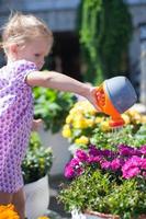 Little cute girl with a watering can for flowers photo