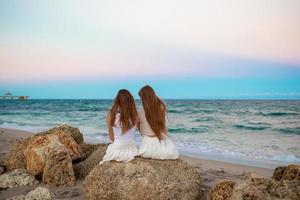 dos hermanas disfrutan del atardecer en la playa foto