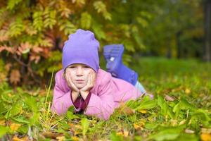 Adorable little girl outdoors at beautiful autumn day photo