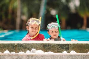 Adorable little girls playing in outdoor swimming pool photo