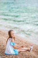 Cute little girl at beach during summer vacation photo