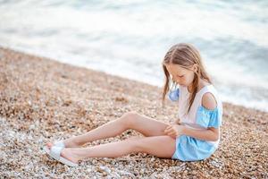 Cute little girl at beach during summer vacation photo