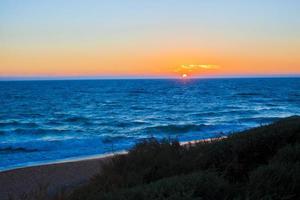 puesta de sol en una hermosa playa en portugal foto