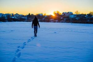 hombre caminando en un campo nevado profundo foto