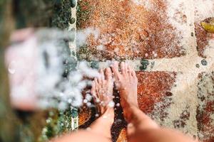 Closeup of female legs under a beach shower photo