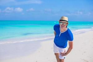 Young happy man enjoying summer vacation on tropical beach photo