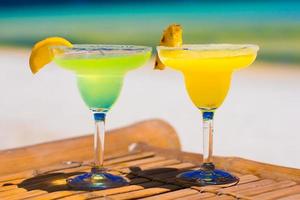 dos sabrosos cócteles alcohólicos sobre el fondo del mar turquesa foto
