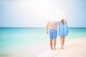 Young family of two on white beach have a lot of fun photo