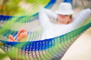 momentos de pereza. hombre con sombrero en una hamaca en un día de verano foto