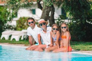 familia feliz de cuatro en la piscina foto