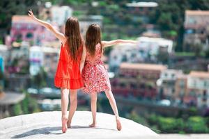 Adorable little girls on warm and sunny summer day in Positano town in Italy photo