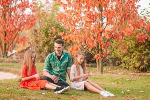 Family of dad and kids on beautiful autumn day in the park photo