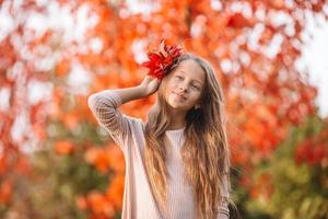 retrato de niña adorable con ramo de hojas amarillas en otoño foto