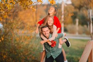 Family of dad and kids on beautiful autumn day in the park photo