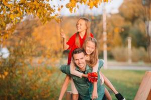 Family of dad and kids on beautiful autumn day in the park photo