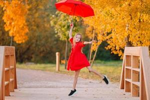 Adorable little girl at beautiful autumn day outdoors photo