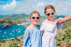 Adorable little kids enjoying the view of picturesque English Harbour at Antigua in caribbean sea photo
