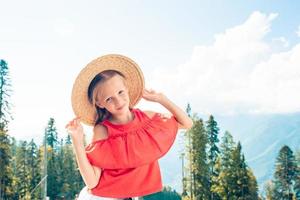 Beautiful happy little girl in mountains in the background of fog photo