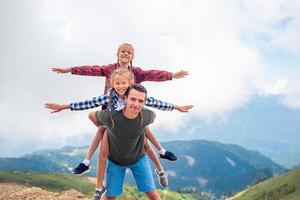 Beautiful kids and happy man in mountains in the background of fog photo