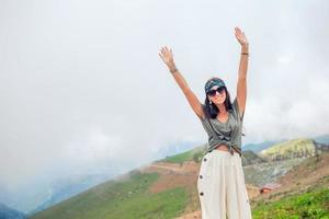 Beautiful happy young woman in mountains in the background of fog photo