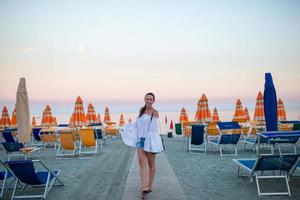 Young woman enjoying summer day on the beach in the sunset. Beach vacation in Europe photo