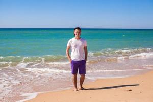 Young man on tropical beach vacation photo