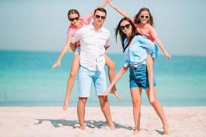 hermosa familia feliz en unas vacaciones en la playa tropical foto