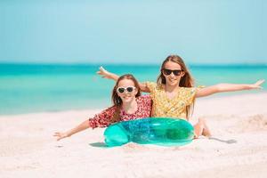 Little happy funny girls have a lot of fun at tropical beach playing together. photo