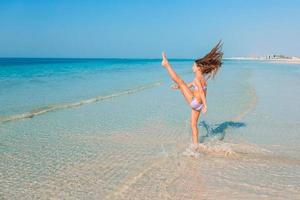 adorable niña activa en la playa durante las vacaciones de verano foto