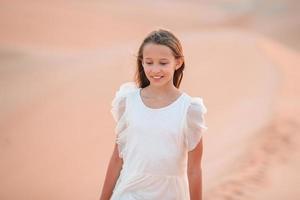 Girl among dunes in desert in United Arab Emirates photo