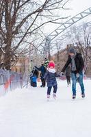 adorable niña y padre feliz en la pista de patinaje al aire libre foto