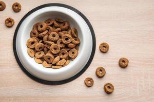 A bowl of dog food on a wooden floor. photo