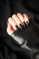 Hands of a young girl with black  manicure on nails photo