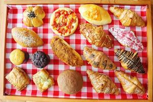 pan surtido pan doble de queso, pan de frijol rojo, muffin de choco, muffin de queso, pollo desmenuzado, croissant de leche de almendras, croissant de res ahumado, salchicha de res foto