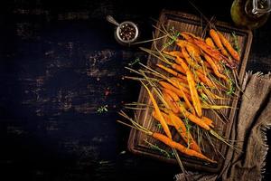 Baked organic carrots with thyme, honey and lemon. Organic vegan food. Top view