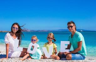 joven familia feliz con dos niños en vacaciones tropicales foto