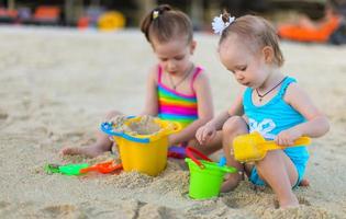 adorables niñas jugando con juguetes de playa durante las vacaciones de verano foto