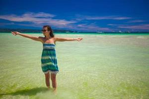 hermosa niña feliz durante las vacaciones tropicales en la playa foto