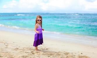 Adorable little girl having fun during tropical vacation photo