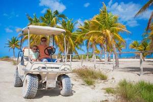 Little girl with father golf cart on tropical beach photo