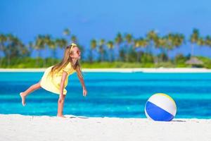 adorable niña jugando con pelota de aire al aire libre en la playa foto