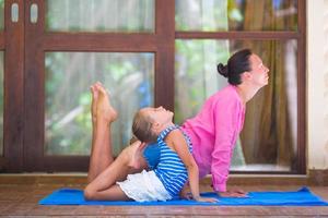 Young woman and little girl engaged in fitness outdoor on terrace photo