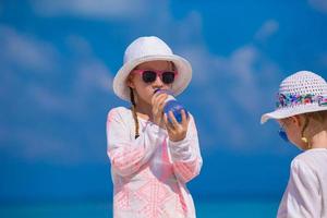Adorable little girls on beach during summer vacation photo