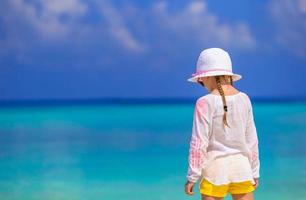 Adorable little girl at beach during summer vacation photo