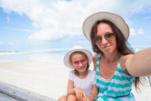 madre y niña tomando selfie fondo el mar foto