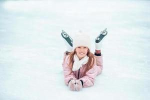 Adorable little girl skating on the ice-rink photo