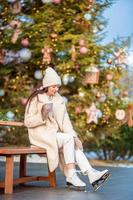 Smiling young girl skating on ice rink outdoors photo