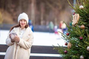 Smiling young girl skating on ice rink outdoors photo